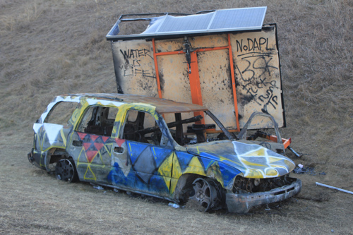 Anti-Trump graffiti spotted on abandoned vehicle near police barricade. Michelle Zacarias } PW