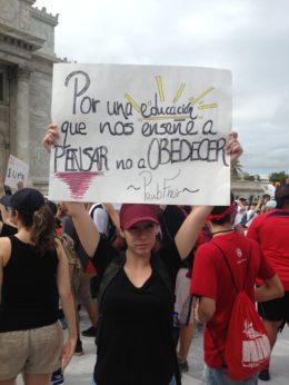 A university student participates in a demonstration in San Juan. Her sign features a quote from Paulo Freire, author of "Pedagogy of the Oppressed," which says, “For an education that teaches us to think, not to obey." | Jean Whitney / PW