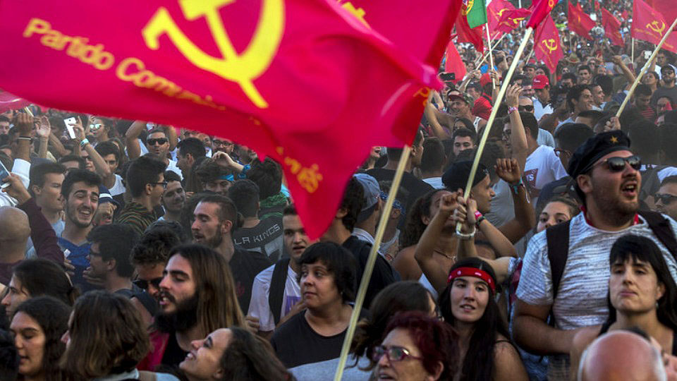 Members of the Portuguese Communist Party Youth carry flags and